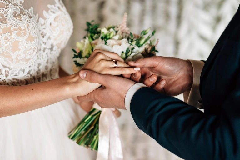 Le marié glisse doucement l’alliance au doigt de sa femme, un moment rempli d’amour et d’émotion.